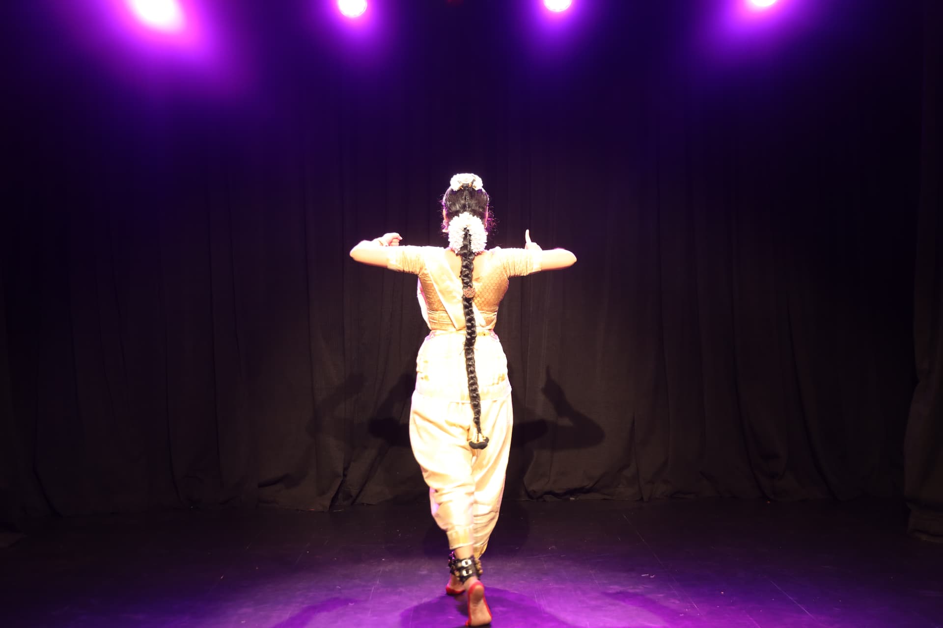 Bharatanatyam dancer seen from behind in a precise classical stance